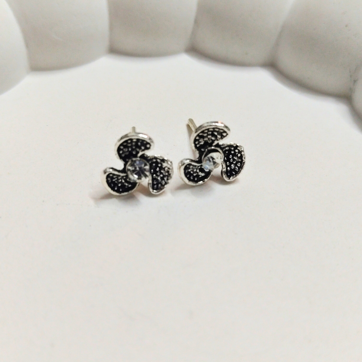 Antique-style flower stud earrings with three textured petals and a central crystal, displayed on a white background