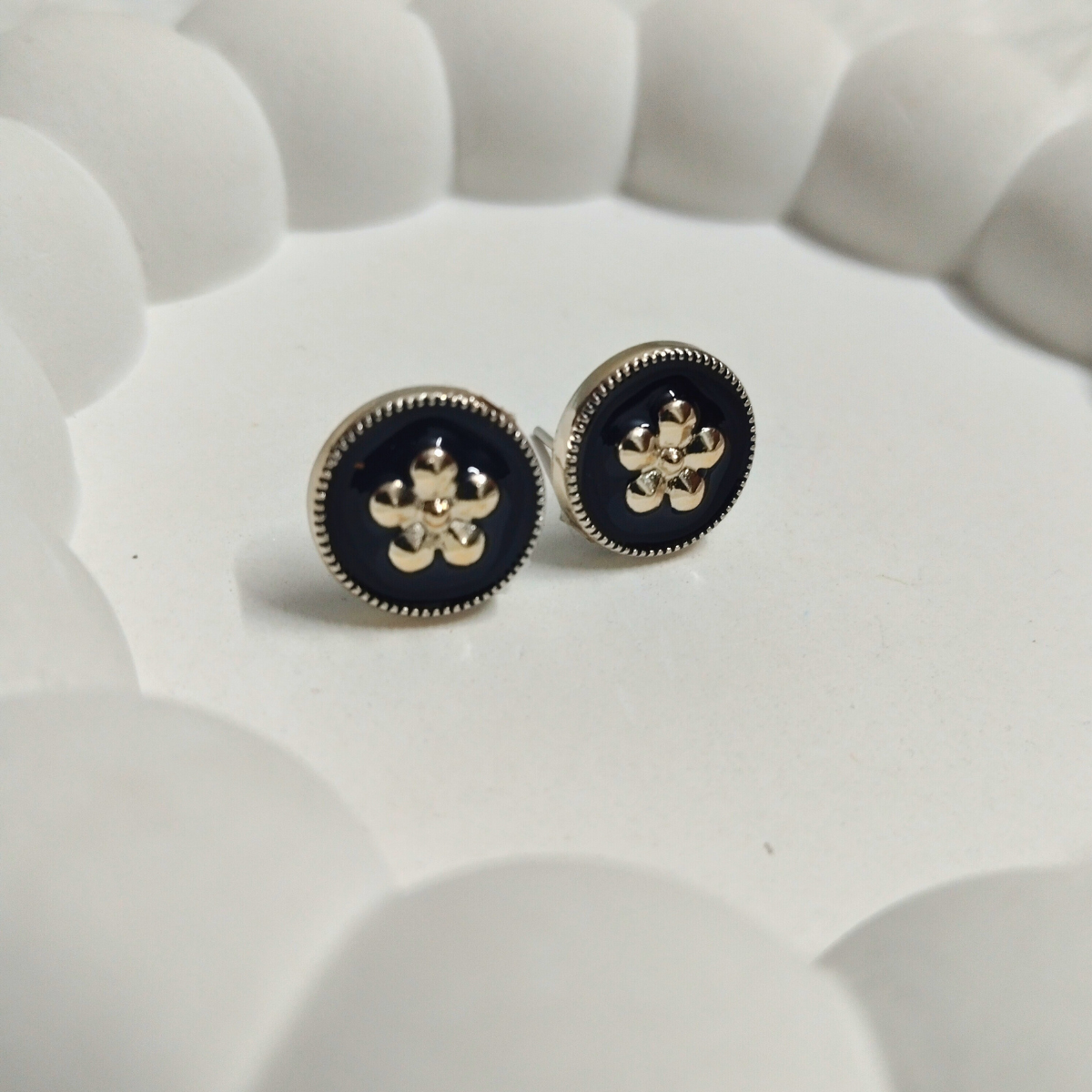 Round black enamel stud earrings with gold floral design and beaded edge