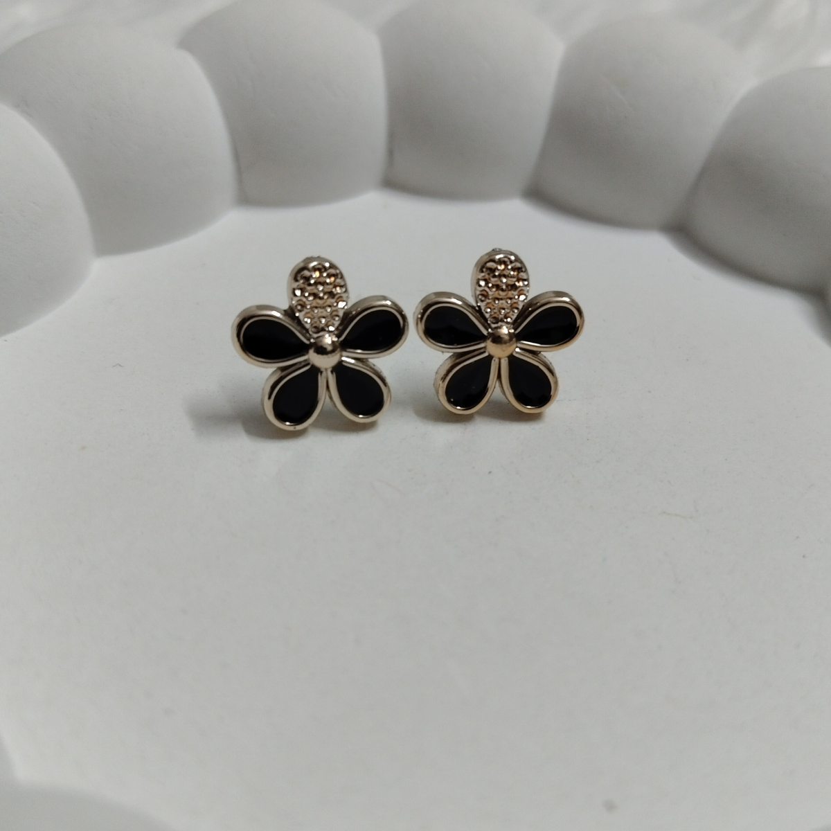 Black flower stud earrings with gold edges and textured beaded top detail