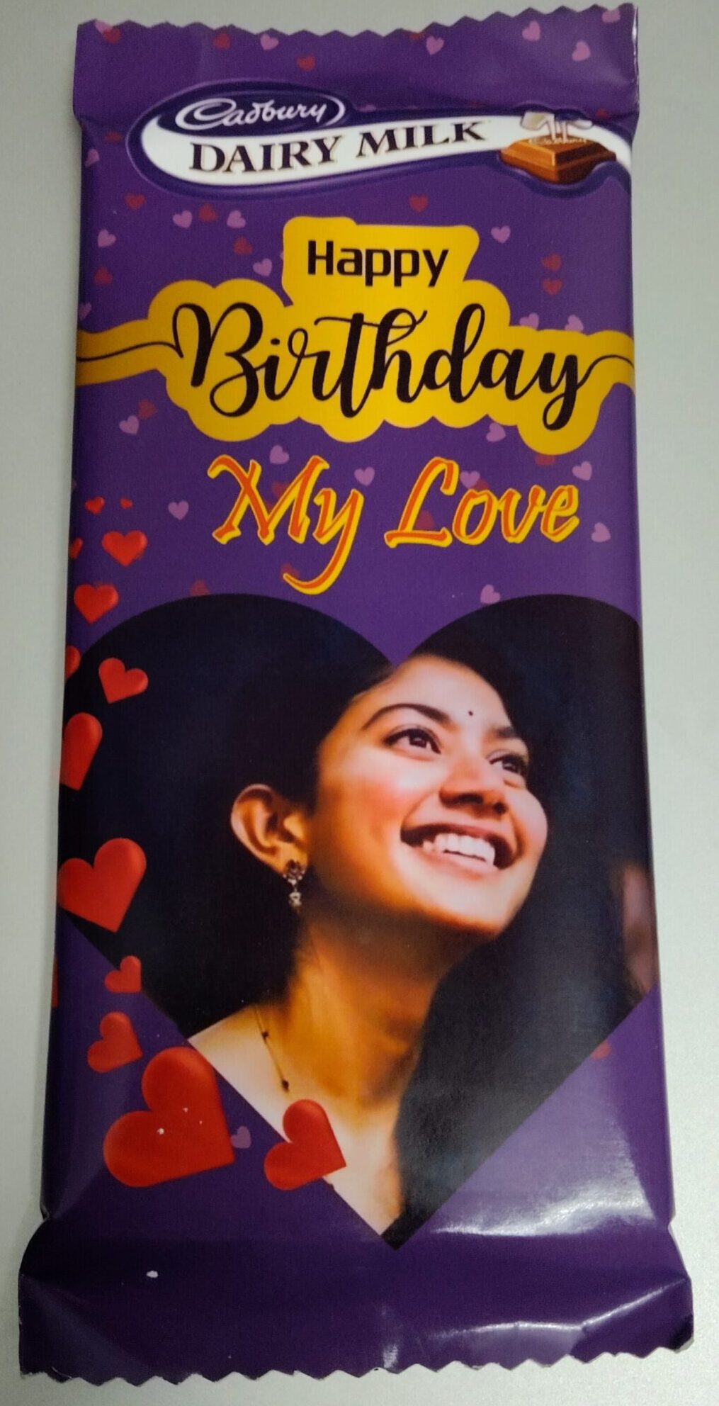 Custom Cadbury Dairy Milk chocolate bar with “Happy Birthday My Love” message and a smiling woman’s photo on the wrapper