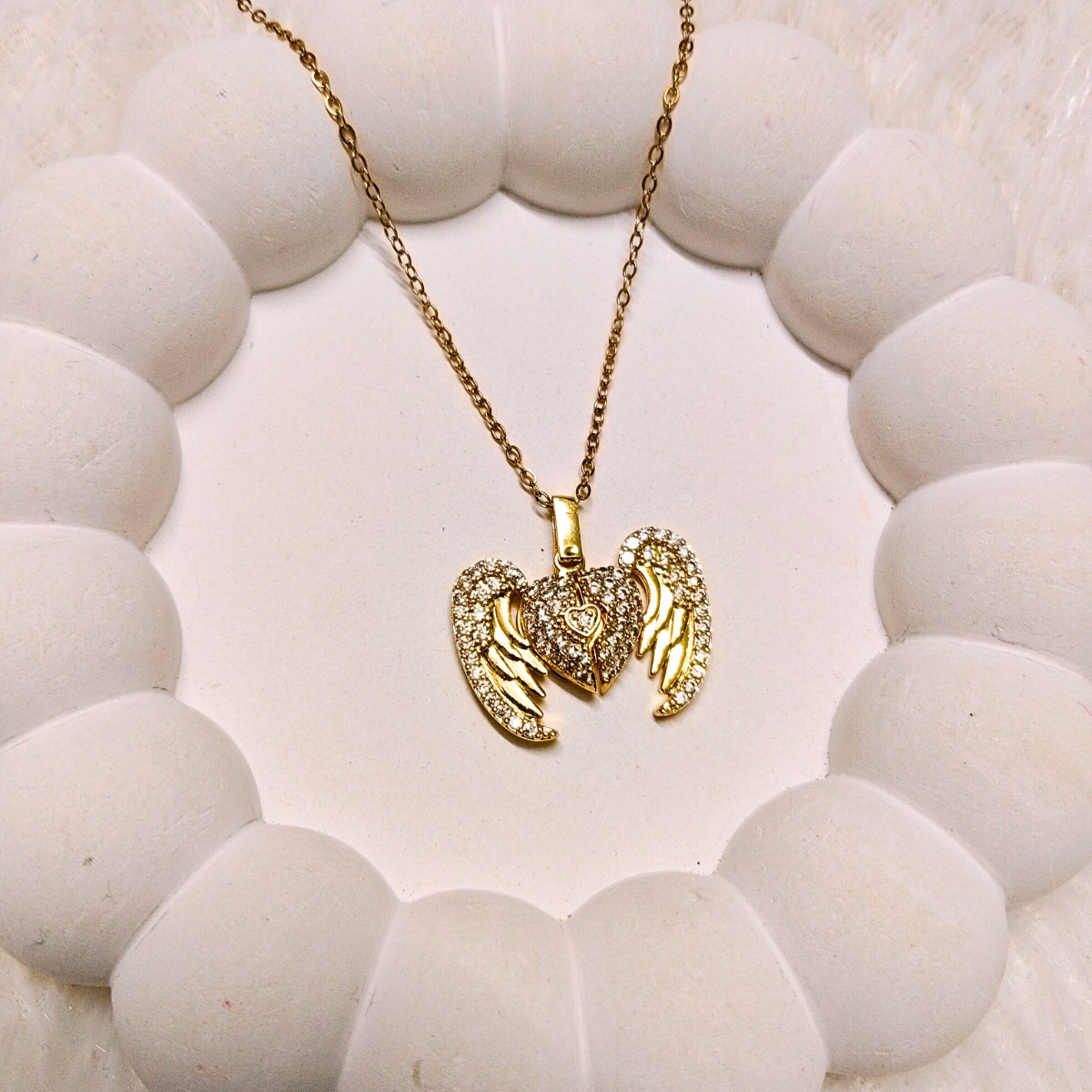 Openable heart pendant with crystal-studded wings in gold finish